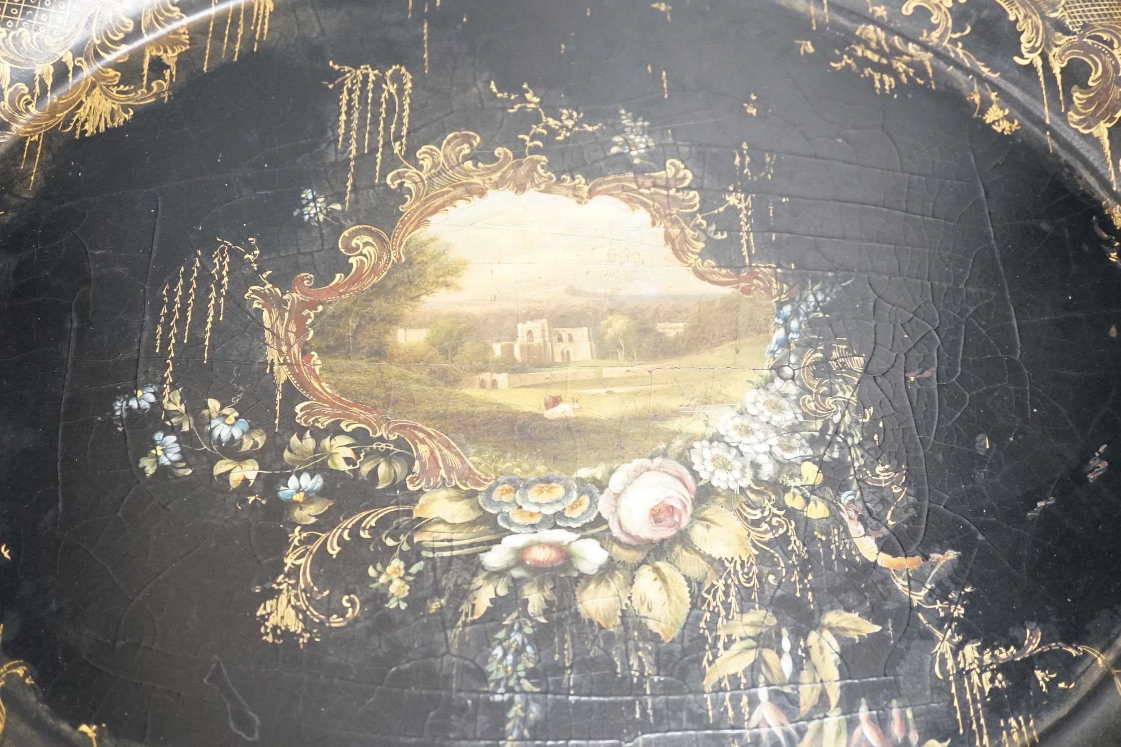 A Victorian papier mache tray, painted with ruins in a landscape - 64cm wide